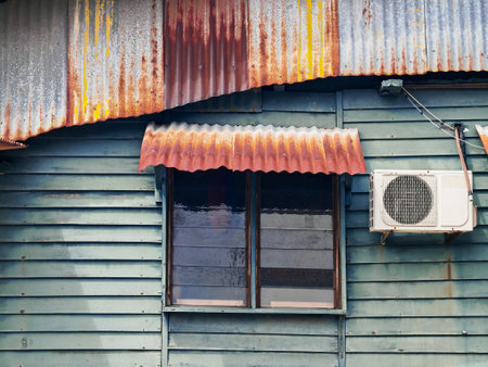 old rusty corrugated metal roof with a window and air conditionerの写真素材