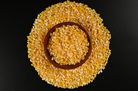Corn seeds in a wooden bowl on a black background, top viewの写真素材