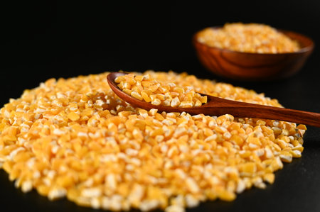 Dry grain in wooden bowl on black background, closeup