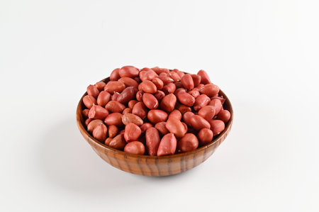 Peanuts in a wooden bowl on white background, close-upの写真素材