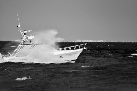 white boat breaking a wave at the caribbean sea in black and whiteの写真素材