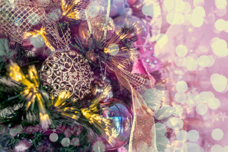 Close up of a christmas tree ornaments baubles ribbons snow flakes and pink bokeh lights. Christmas card background wallpaper celebration conceptの写真素材