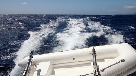 yacht wake with a tender at the stern