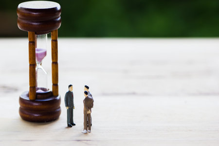 Financial investment negotiation,discussion among CEO or execute level concept: Miniature figurine three businessmen talk on time invest contract agreement, discuss about company time in future.の写真素材