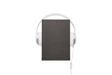 Audio book concept. Black book and white headphones set isolated on white background with copy space.の写真素材