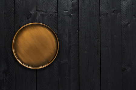 Top view of golden stylish serving plate on black wooden table with copy space.の写真素材