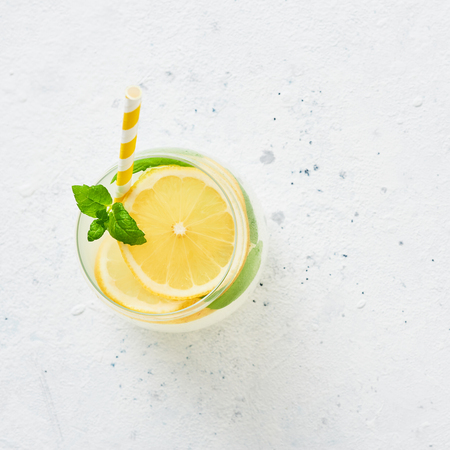 Ice cold summer drink. Traditional lemonade or mojito with lemon, mint and ice on white background. Top view. Copy space for text. Square crop.の写真素材