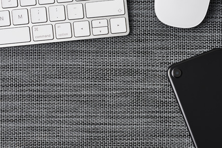 ZAGREB, CROATIA - NOVEMBER 22, 2018: Business composition with white computer keyboard, mouse and black phone on grey background. Top view with copy space for text.のeditorial素材