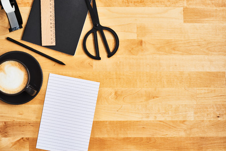 Black office or school supplies. Notepad, pencil, scissors, scotch tape, cup of coffee and an empty...