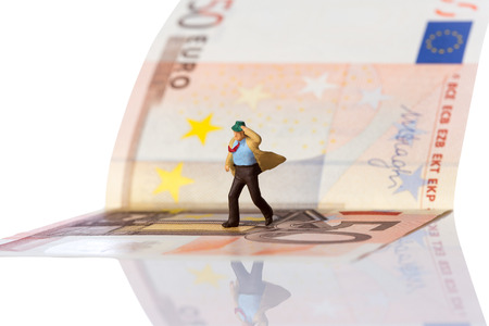 businessman figurine running on a euro banknote,isolated on white with clipping pathの写真素材