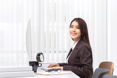 Attractive woman working in office on laptopの写真素材
