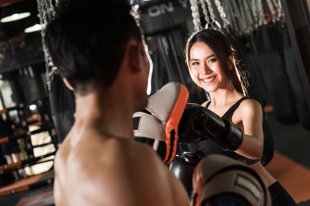woman training with boxing gloves at the gym,Couple exercising punchingの写真素材