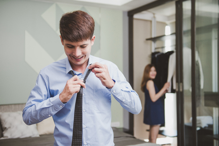 Cheerful smiling young couple with new apparel at fitting-room in changing room at bedroom.の写真素材
