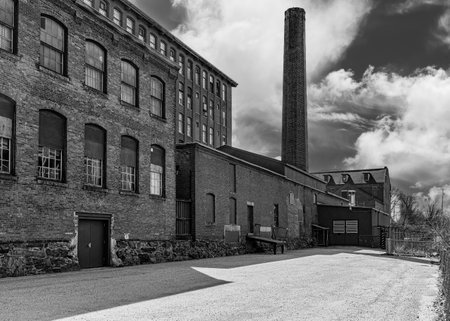 Old brick factory building with chimney and road. Black and white photographyの写真素材