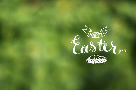 Happy Easter lettering calligraphy on lens blured green backgroundの写真素材