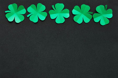Emerald green paper clover shamrock leafs border frame on background