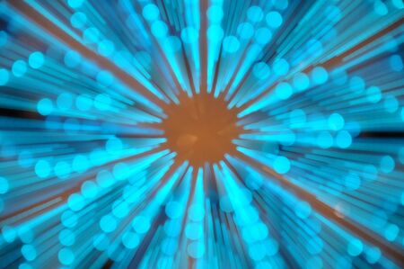 Photograph of zoom burst motion of arctic blue light with orange light background