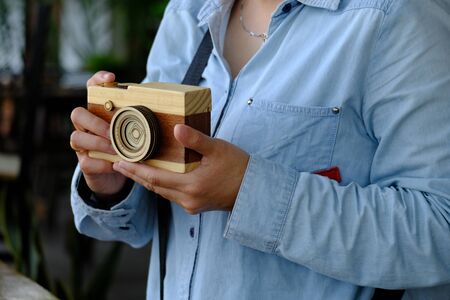 Asian woman hold wooden camera, pretend to take photoの写真素材