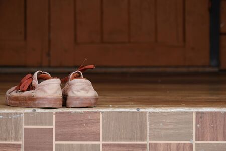 Student old brown standard shoes or sneakers on the wooden floor of school ancient building on semester closeの写真素材