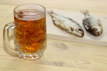 light beer with a salted fish on the table of woodの写真素材