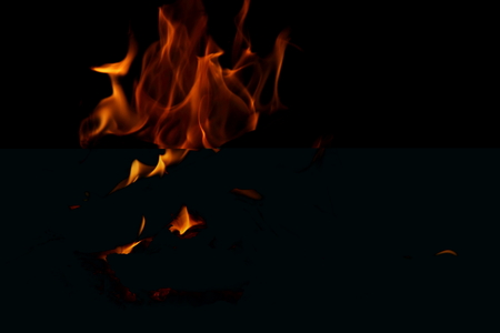 Closeup of a large fire. Wooden planks to the fire. The fire is lit in the night.