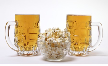 pint of cold light beer and salty popcorn on a white backgroundの写真素材