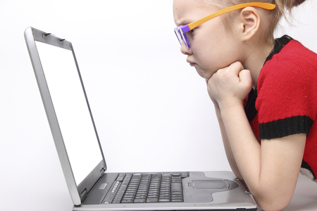girl to be angry in front of the laptop screen. white background. orange glassesの写真素材