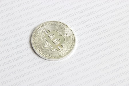 silver bitcoin on the background of binary codeの写真素材