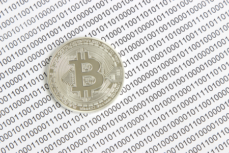 silver bitcoin on the background of binary codeの写真素材