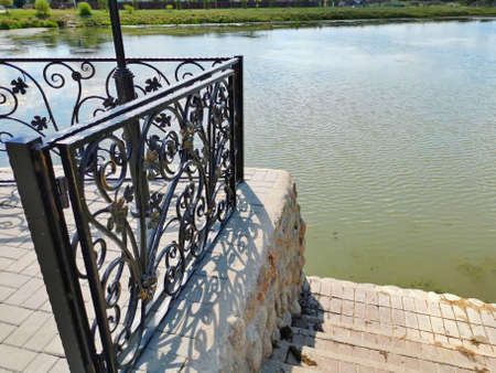 steps leading to the water forged railings pond parkの写真素材