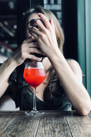 Cocktail dressing up Girl using electronic gadget. Indoors, copy space. Modern technology. Communication with the friends.の写真素材