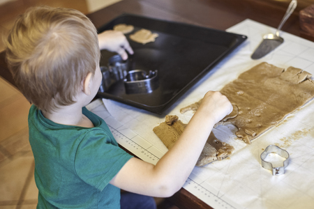 Cute caucasian baby boy helps in kitchen, making coockies. Casual lifestyle in home interior, pretty child alone. Indoors, copy space.の写真素材
