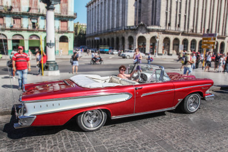 Havana / Cuba - 07/2018: Old and rusty cars of fifties (rented) in Havana. Red Edsel Pacer from side proection with caucasian woman as a driver. Outdoors, sunny day, copy space.のeditorial素材