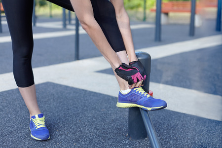 Female sneakers preparing for a jog, run or other fitness. Morning workout on outdoors background....