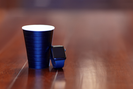 Black coffee cup and electronic watch with black screen (copy space for numbers of time). Concept of break for coffee. Indoors, copy space, selective focus.の写真素材