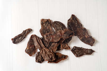 Sliced beef kindey dehydrated and lying down on white background. Homemade natural dry dog treats. Closeup, copy space.の写真素材