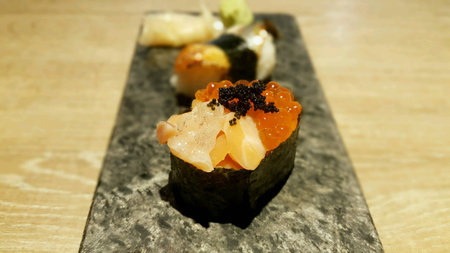 Salmon eggs and tuna sushi roll in rectangle plate on wooden tableの素材