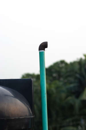 Black water tank on the roofs with blue air filter pipe