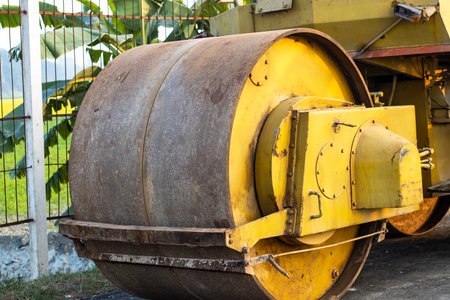 Old yellow road roller front wheel close viewの写真素材