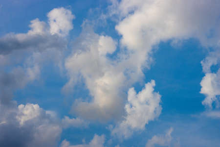 White clouds moving under the sunny blue sky