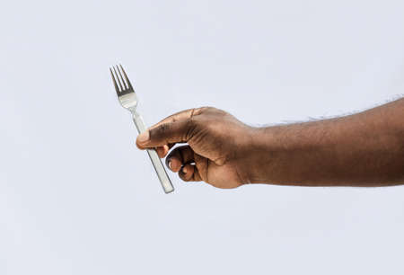 A male holding a fork with two fingers on isolated white background