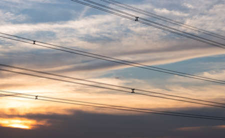 Beautiful dramatic sunset sky above the high voltage wire in the eveningの写真素材