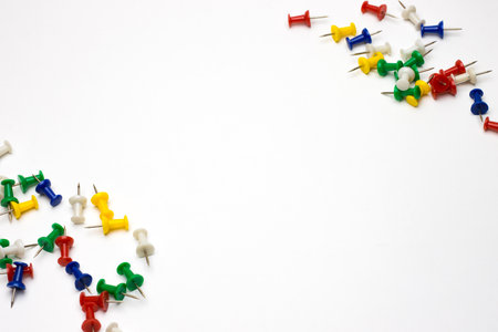 Scattered thumbtack pins in the corner on white background with text spaceの写真素材