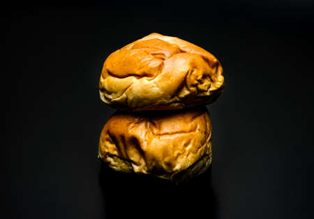 A pile of two delicious burger buns on dark backgroundの写真素材