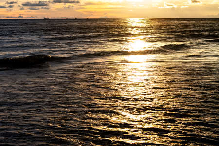 Golden sunlight reflection on the sea in the evening