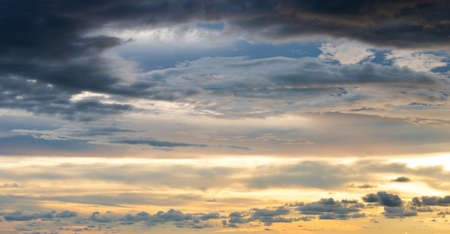 Evening sky with bright sunlight and dark blue clouds