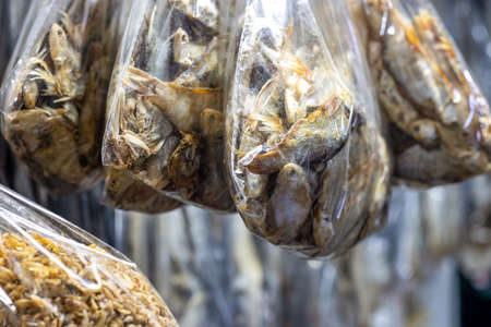 Hanging salted dried sea fishes on a seafood market close upの写真素材