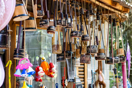 Child toys and decorative musical instruments hanging in the shop close up
