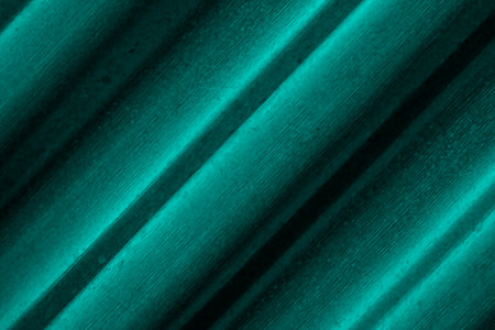Rough textured cyan color old corrugated metal sheet close up perspective view for backgroundの写真素材