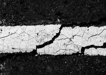 Close up top view of a black and white cracked asphalt road for texture background